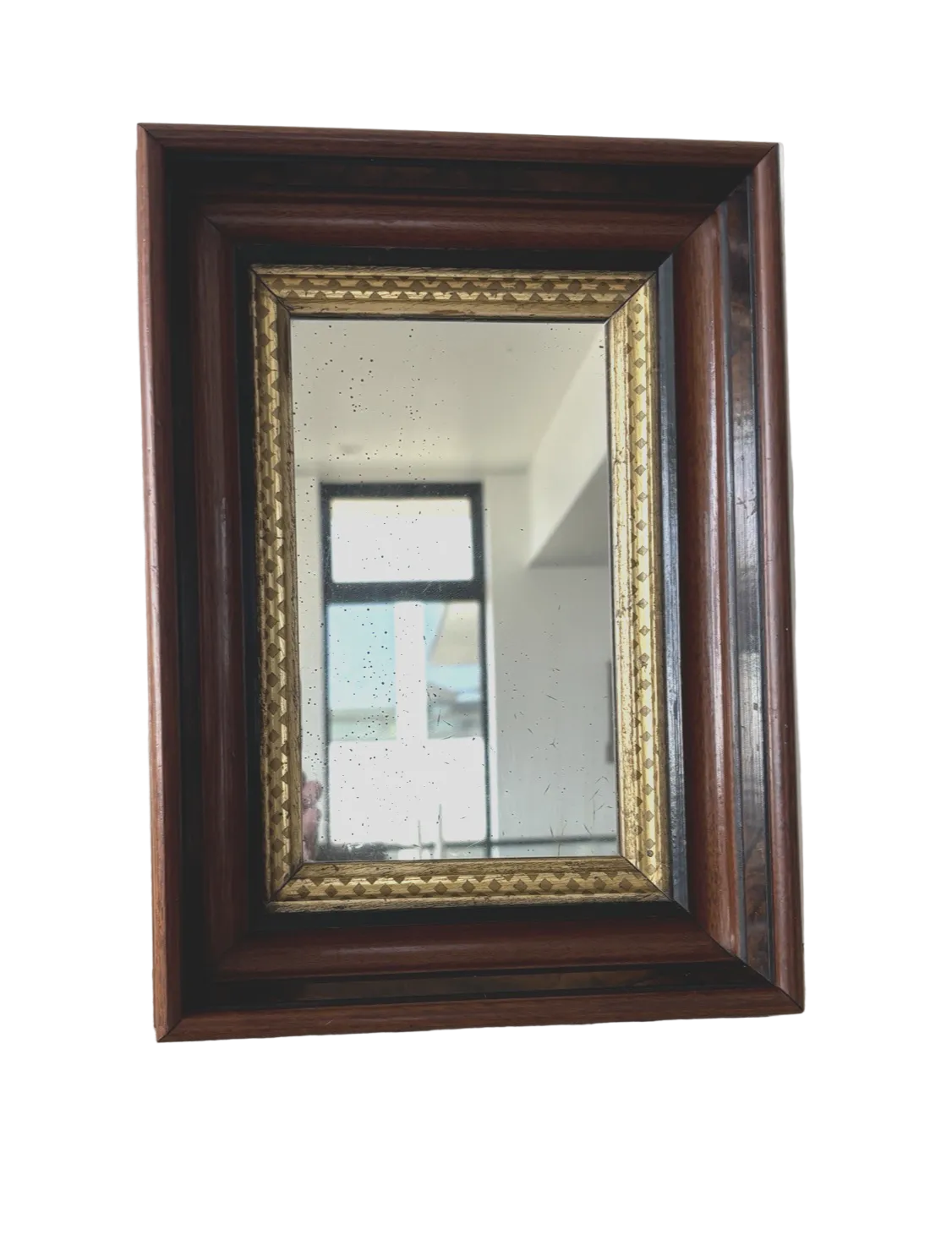 A rectangular wall mirror with an Eastlake style deep welled wood frame and an ornate gold liner.