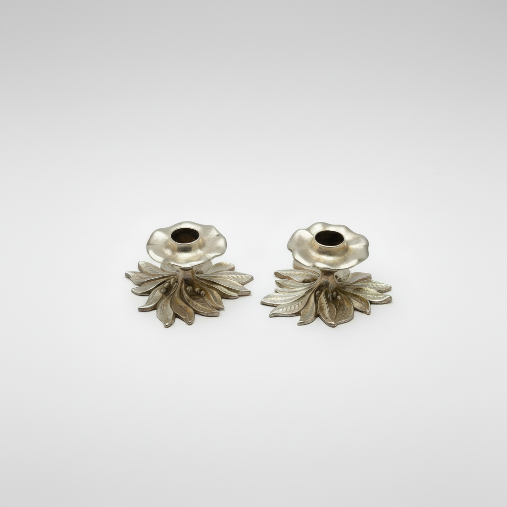 A pair of vintage cast brass candlesticks with leaf and berry motif bases and candle cups in the shape of flowers.