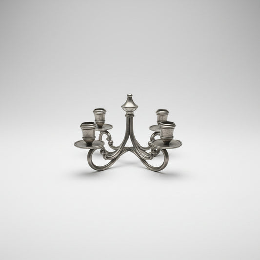 A four-light silver pewter candelabra with curved arms, rimmed drip pans and candle cups.